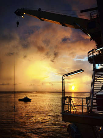 Offshore oil platform in evening.Among beautiful sunset.Crude oil is sucked up from the depths of the sea and manufacture or refined become oil by factory.Landscape background.View of copy space.の写真素材