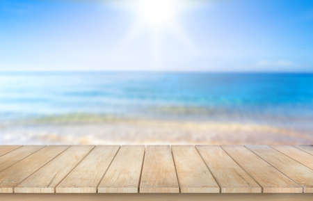 Wooden table top on blur blue sea  background in summer season.For montage product display or design key visual layout.View of copy space.の写真素材