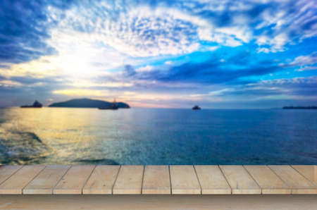 Wooden table top on blur blue sea  background in summer season.For montage product display or design key visual layout.View of copy space.の写真素材