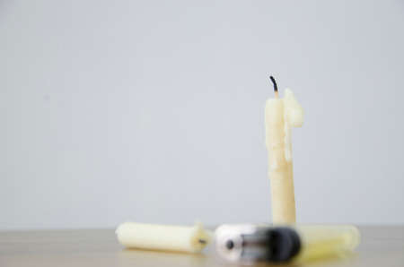 Old candle on wooden table with lighter.Ready for fire.Light is like knowledge.View of copy space.の写真素材