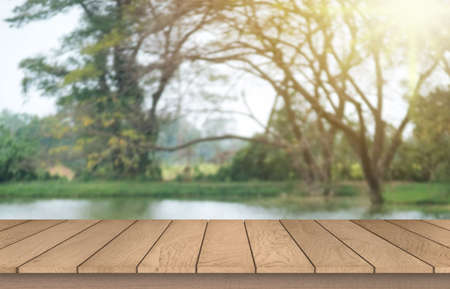 Wooden table top on blur green forest or gardent.Fresh and Relax concept.For montage product display...