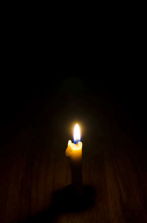 Warm light fire of candle isolated on black background.illuminate in dark night.Hot and shiny.Use candle in festival,ceremony or night.View of copy space.の写真素材