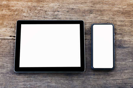 Tablet and smartphone are on the wooden desk.Communication network,social media,online shopping or Business management concept.White or blank screen for decorate Advertising.View of copy space.の写真素材