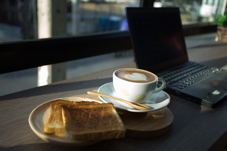 Cappuccino, latte blended with honey and put it on toast in coffee shop.の写真素材