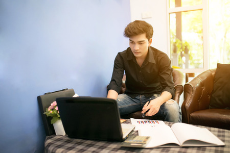 Young Asian business man looking at shares.の写真素材
