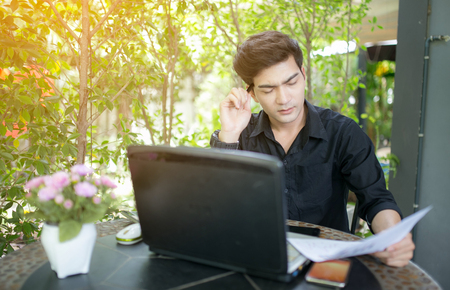 Young Asian business man looking at shares.の写真素材