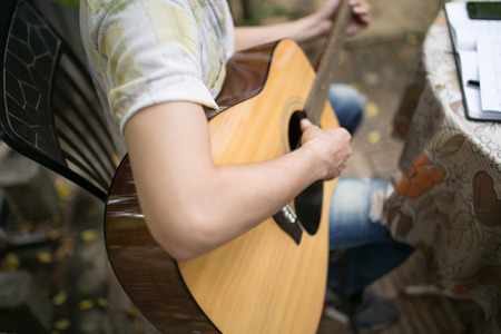 Guy plays guitar in the backyard.の写真素材
