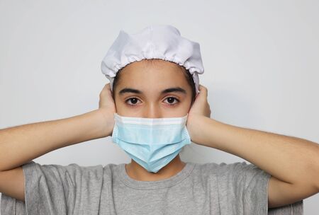 Asian girl in an infectious disease mask shows sick and sad gestures with tears, a health care concept to prevent the flu with a white screen background.の写真素材