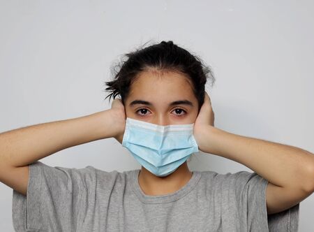Asian girl in an infectious disease mask shows sick and sad gestures with tears, a health care concept to prevent the flu with a white screen background.の写真素材