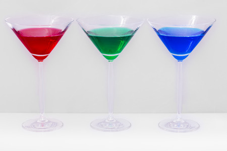 three glasses of green and red colors on white backgroundの写真素材