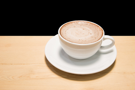 cup of coffee on wood table isolated on black backgroundの写真素材
