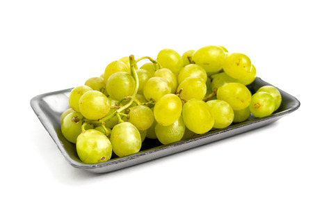 Green grape bunch in silver tray with white isolated backgroundの写真素材