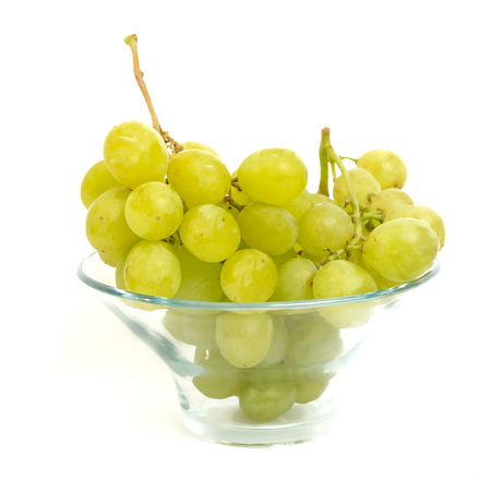 Green grape bunch in a clear bowl with white isolated backgroundの写真素材