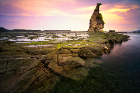 Beautiful seascape scenery of big boulder stone during sunset at Tanjung Layar beach in Sawarna, Banten, Indonesia.Soft focus during long exposure shoot.の写真素材