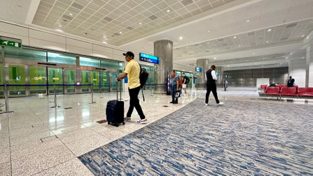 DUBAI, UNITED ARAB EMIRATES. 16 SEPTEMBER 2023. Travelers pacing through the vibrant interiors of Dubai International Airportのeditorial素材