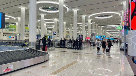 DUBAI, UNITED ARAB EMIRATES. 15 SEPTEMBER 2023. A bustling scene at Dubai International Airport's luggage retrieval conveyor areaのeditorial素材
