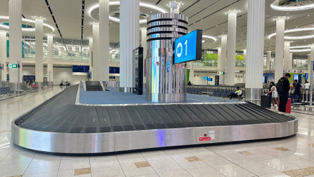 DUBAI, UNITED ARAB EMIRATES. 15 SEPTEMBER 2023. Busy scene at Dubai Airport's luggage conveyer, filled with awaiting travelersのeditorial素材