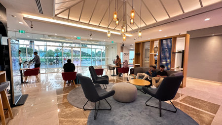 DUBAI, UNITED ARAB EMIRATES. 16 SEPTEMBER 2023. Guests sit, engaged in quiet anticipation within an active hotel lobbyのeditorial素材