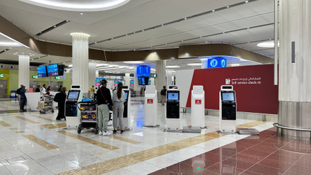 DUBAI, UAE. 16 SEPTEMBER 2023. Travelers at Dubai Airport's self-service check-in, signalizing modernization in air travelのeditorial素材