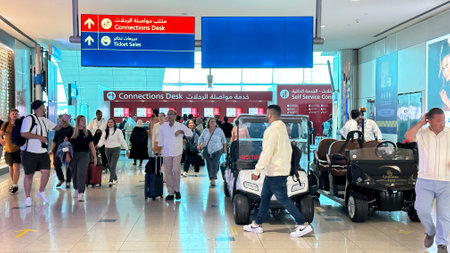 DUBAI, UAE. 16 SEPTEMBER 2023. Travelers proceeding to Dubai Airport's connections desk, capturing the global transit hubのeditorial素材