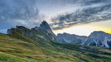 Emerald valleys cradle the Dolomites' sheer cliffs, basking in Italy's pristine daylight.の写真素材