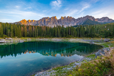 Lago di Carezza's emerald waters, misty forests, and Latemar views form an unrivaled Alpine charm. A beloved spot in South Tyrol and the Dolomitesの写真素材