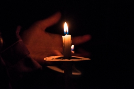 Hand holding burning candleの写真素材