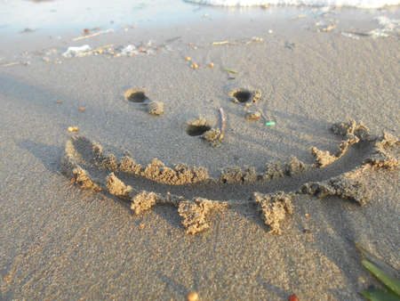 Happy face on sandの写真素材