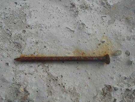 Rusty nail on a concrete floorの写真素材
