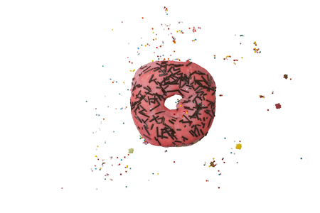 Donut in pink glaze with colored confectionery toppingの写真素材