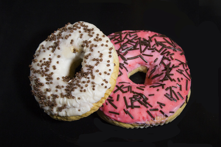 Donuts in glaze on a black backgroundの写真素材