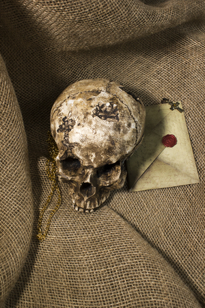 Damaged skull with a vintage letter, with a burlap backgroundの写真素材