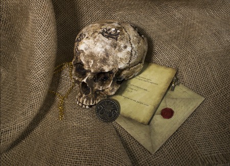 Damaged skull with a letter, with a burlap backgroundの写真素材