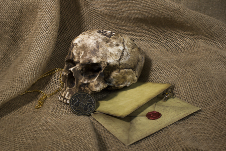 Damaged skull with a letter, with a burlap backgroundの写真素材