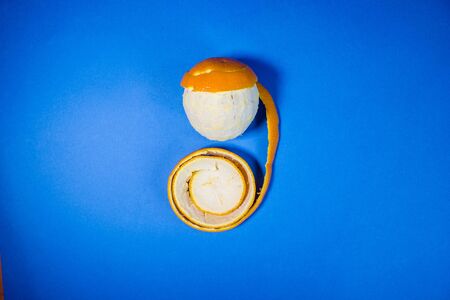 Orange in a peel on a blue backgroundの写真素材