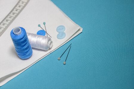 Blue textured background with sewing tools, copy space on background. Frame with sewing tools and...