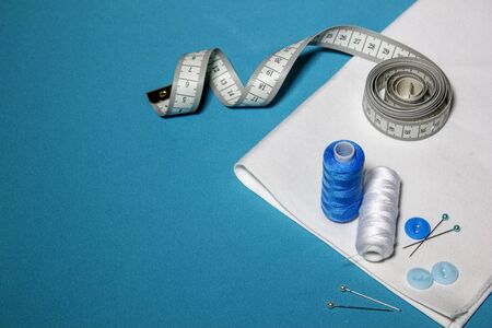 Blue textured background with sewing tools, copy space on background. Frame with sewing tools and accessories. Top view.の写真素材