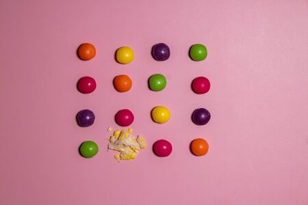 Broken candy among whole ones on color background. Concept of uniquenessの写真素材