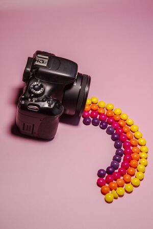 photo camera and multi-colored candies skills, concept photo with rainbow from camera