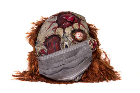 severed head with medical mask on a white background