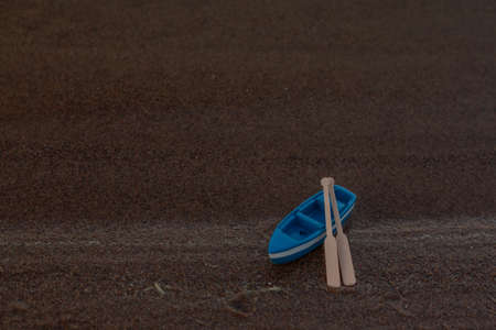 blue wooden boat stands on the shore with oarsの写真素材