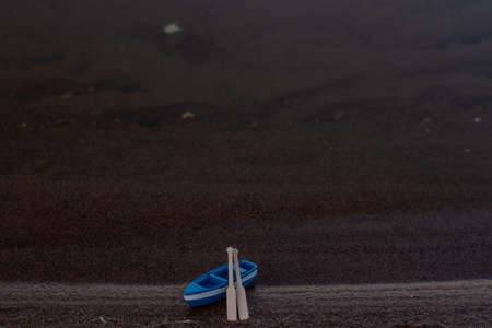 blue wooden boat stands on the shore with oarsの写真素材