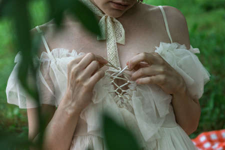 beautiful girl in nature in a romantic white dress close up