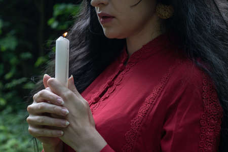 beautiful young girl in a red dress with long sleeves and a wreathの写真素材