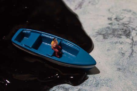 ecology theme, water pollution, a man in a boatの写真素材