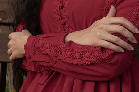 beautiful young girl in a red boho dress with long sleeves walks in the parkの写真素材