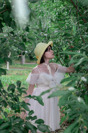 girl in white dress and straw hat, portrait on natureの写真素材