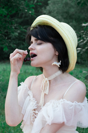 girl in white dress and straw hat, portrait on natureの写真素材