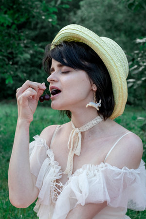 girl in white dress and straw hat, portrait on natureの写真素材