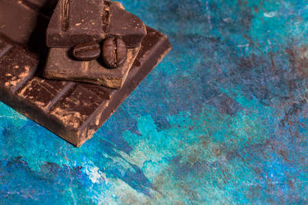 Broken pieces of chocolate on blue abstract background. Top view.の写真素材